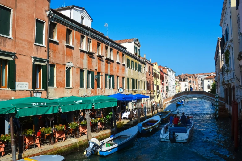 boats in the water on a waterway between some buildings