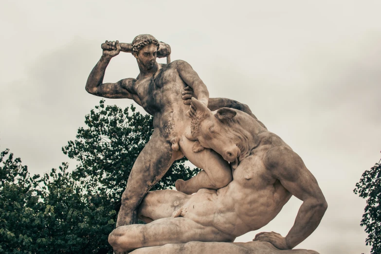 there is a statue with a man wrestling another