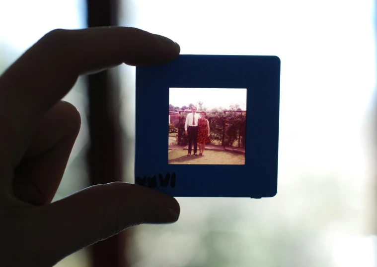 the person is holding up a polaroid in front of the camera