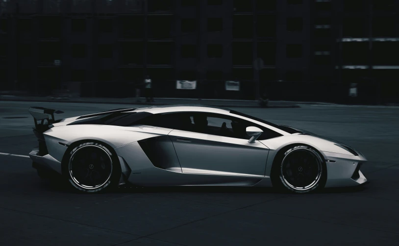 the front end of a white sport car parked in an urban parking lot