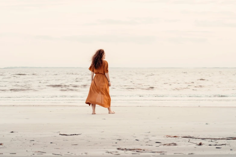 a person stands on a beach next to the water