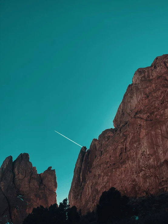 a plane flying past some big rocky hills