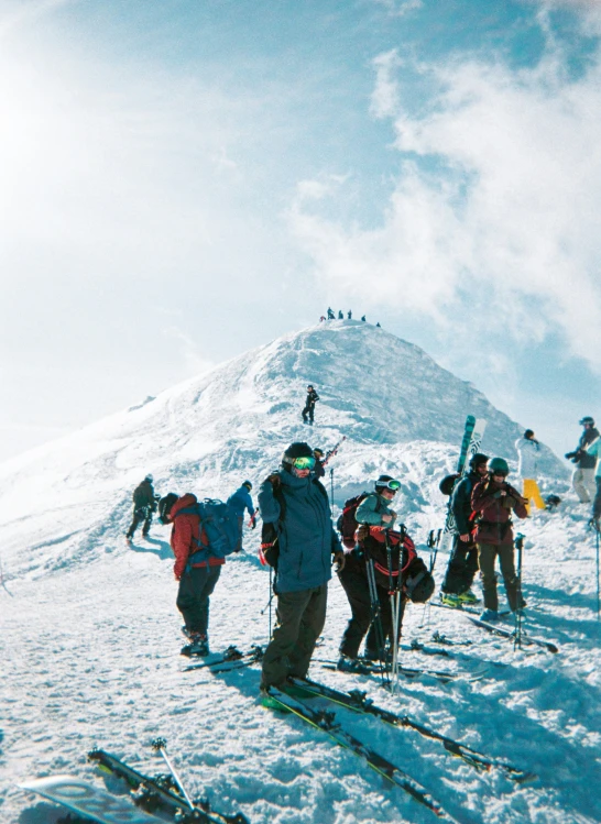 skiers at the top of a ski slope in their gear