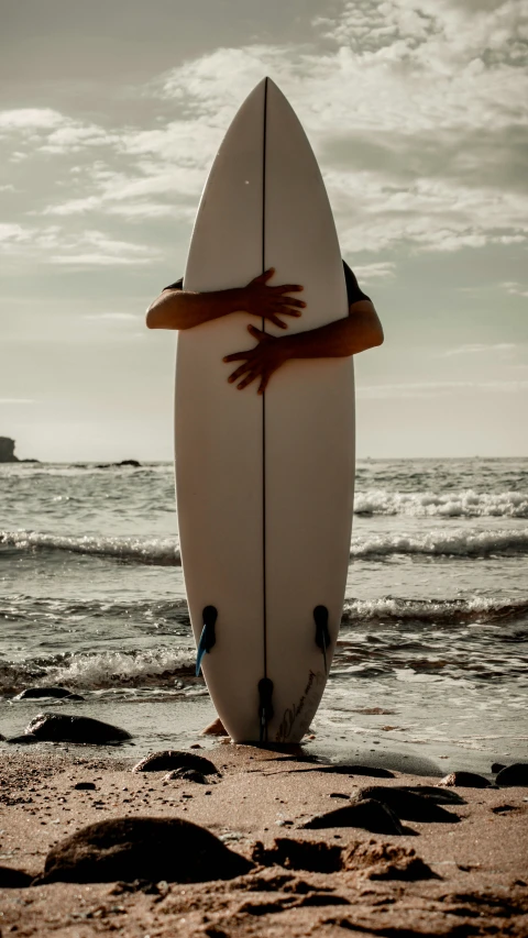 a person holding a surfboard on top of a beach