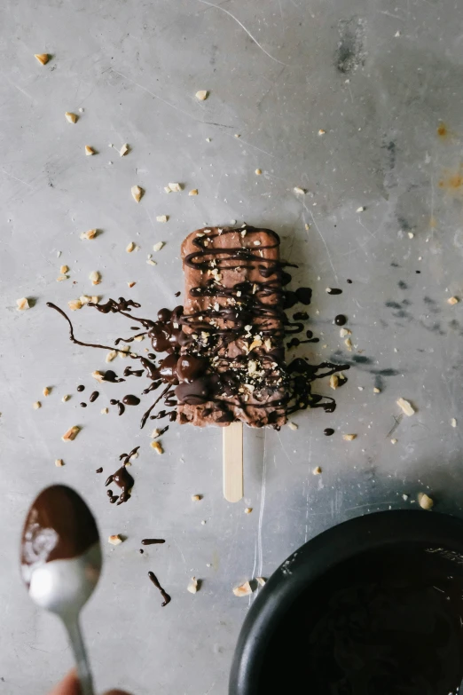 a person with a spoon is eating food from an ice cream sundae