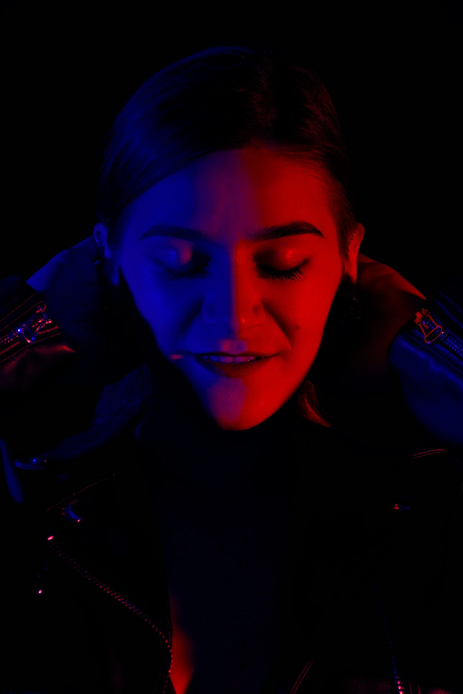 a woman in a dark room with her eyes closed