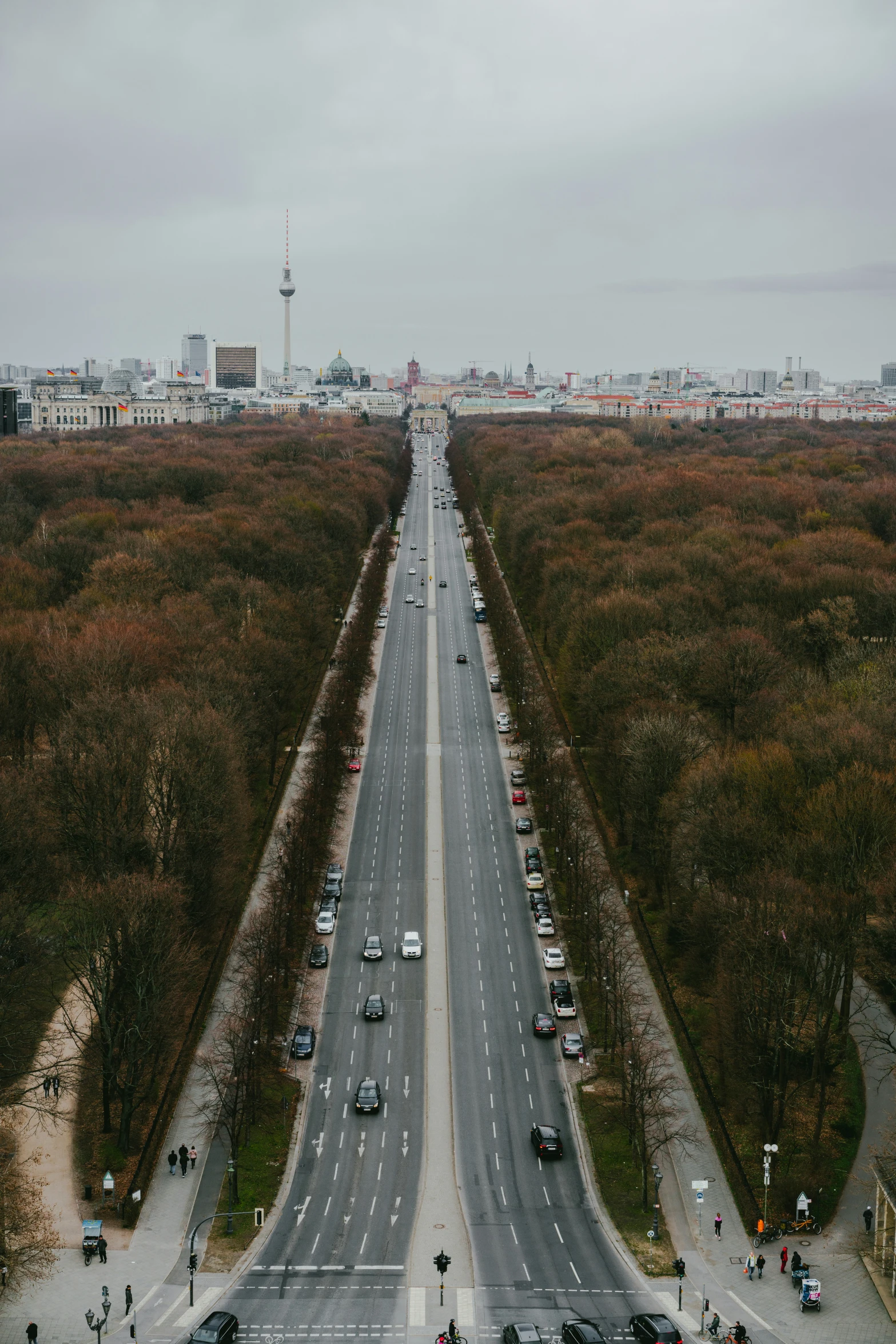 the view from the air shows two roadways running along an empty field with green trees