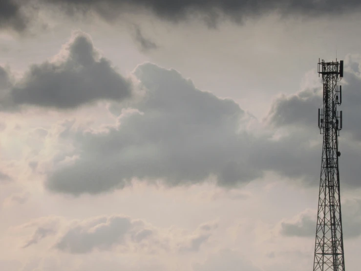 there are two cell towers under some clouds