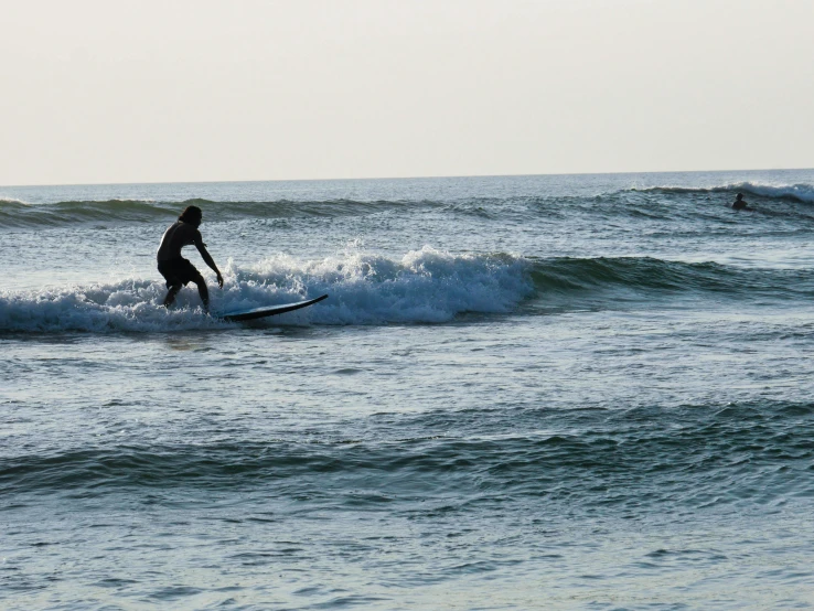 two people standing in the ocean with surfboards