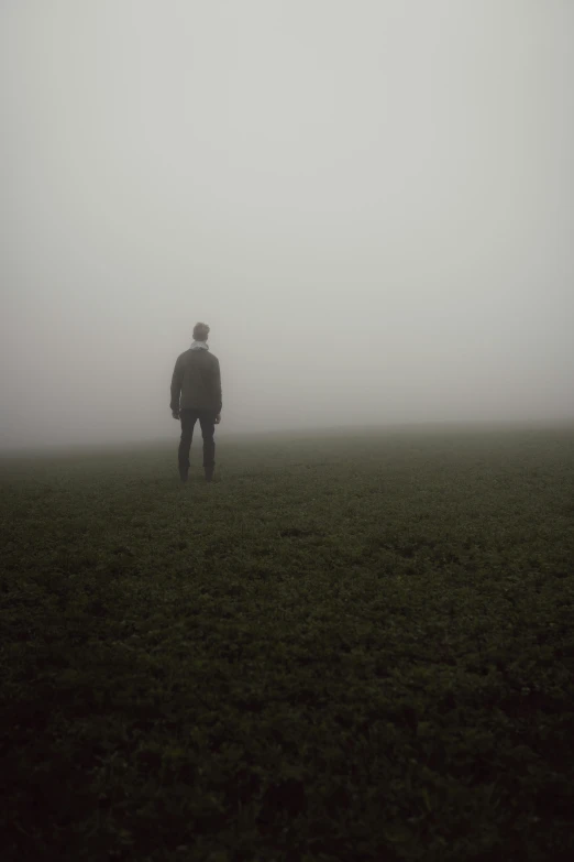 a man in a foggy field looking over the top