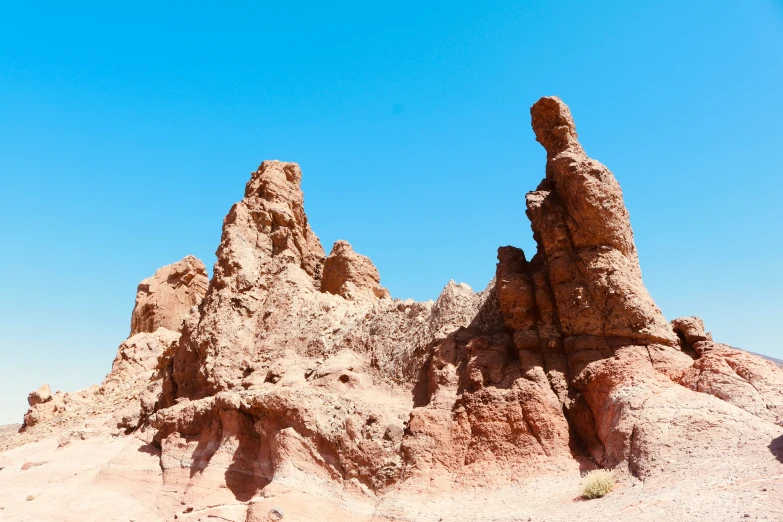 the view of some rocks in the desert against a blue sky