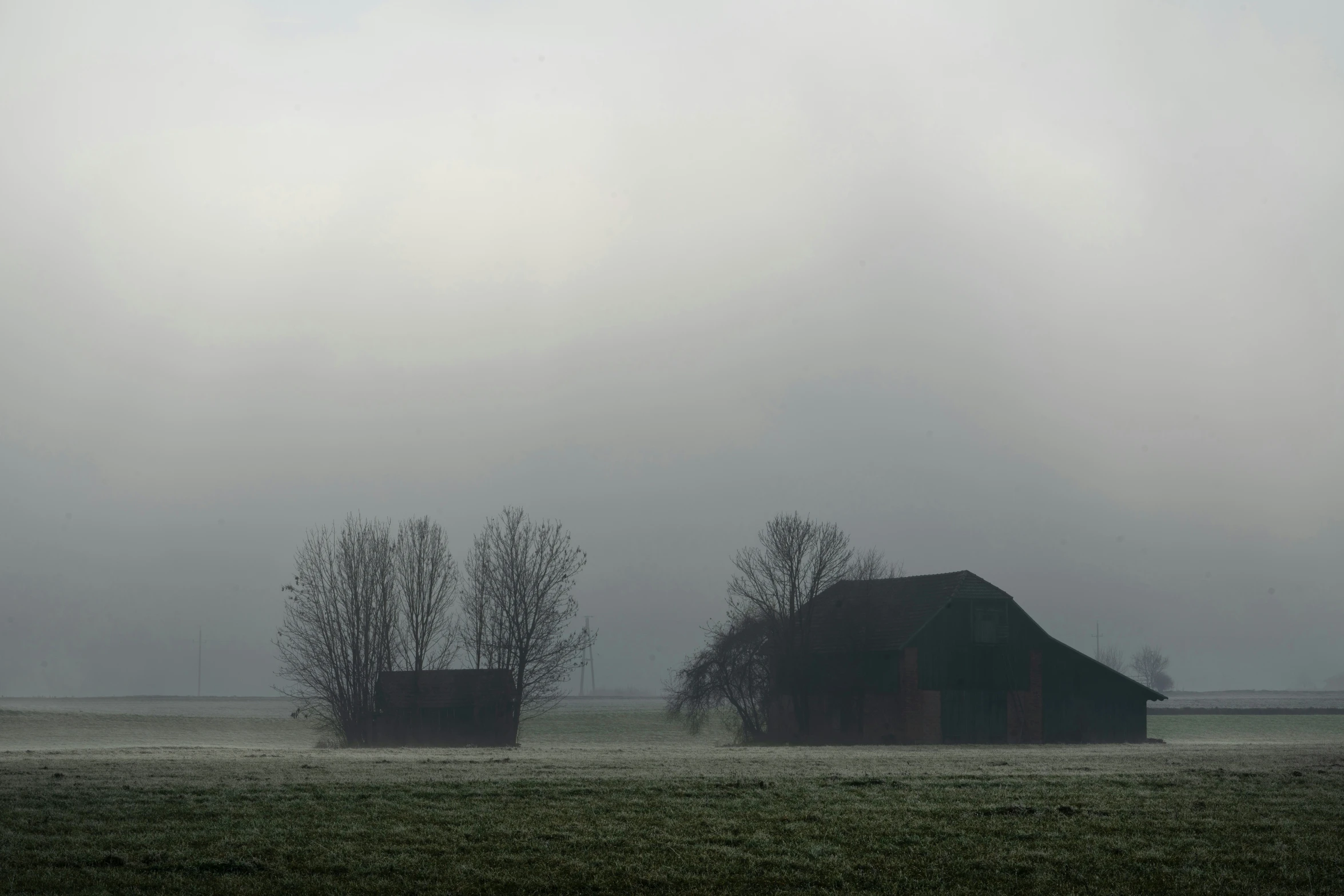 an old barn is seen in the fog
