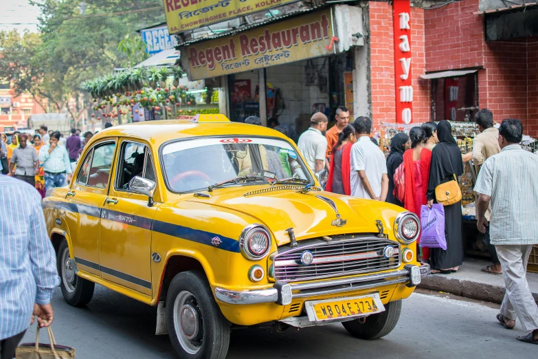 taxi cab at a street fair in front of a large group