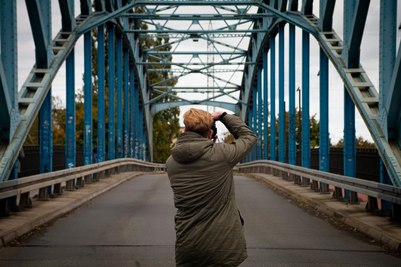 a person taking a picture of some tall metal beams