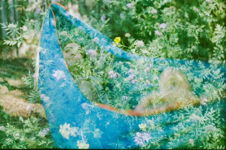 two hammock in some trees surrounded by some flowers