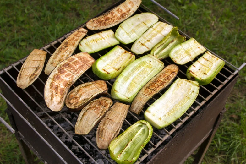 food on a grill with some sliced up zucchini