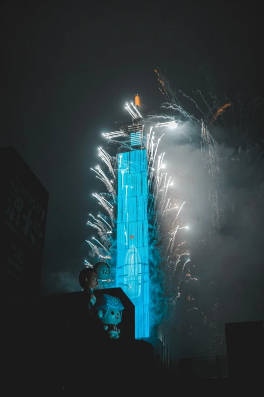 the fireworks light up the night sky behind a building