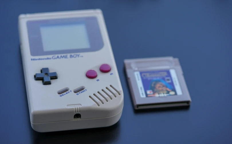 an old gameboy and a small dvd player on a table