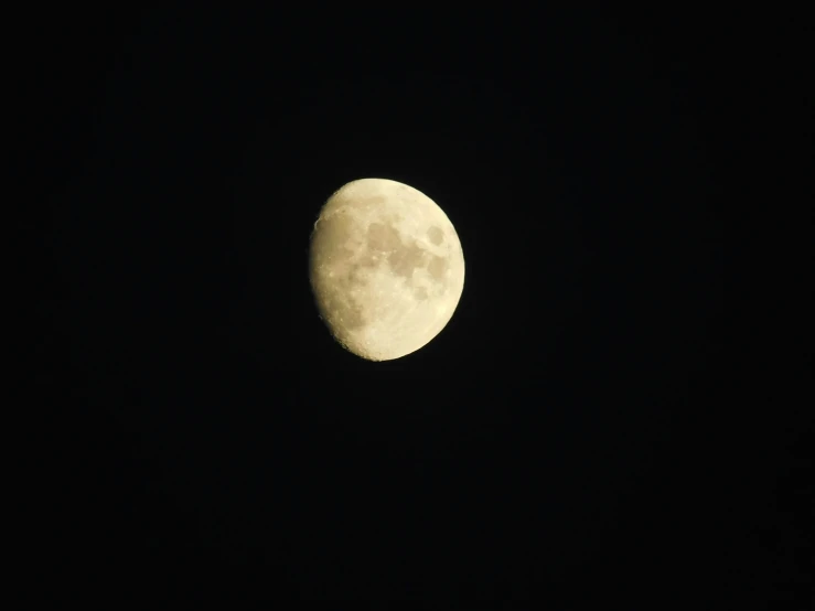 the moon is above a building with only the dark night sky