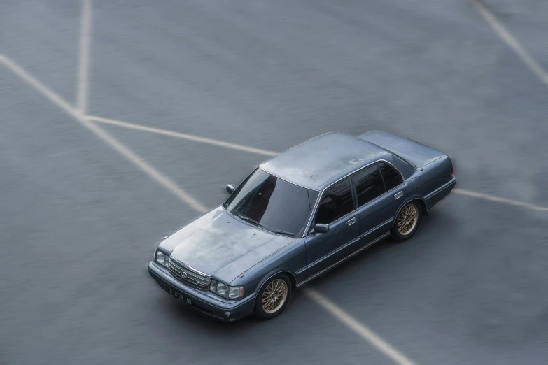 silver car parked in lot with pavement on both sides