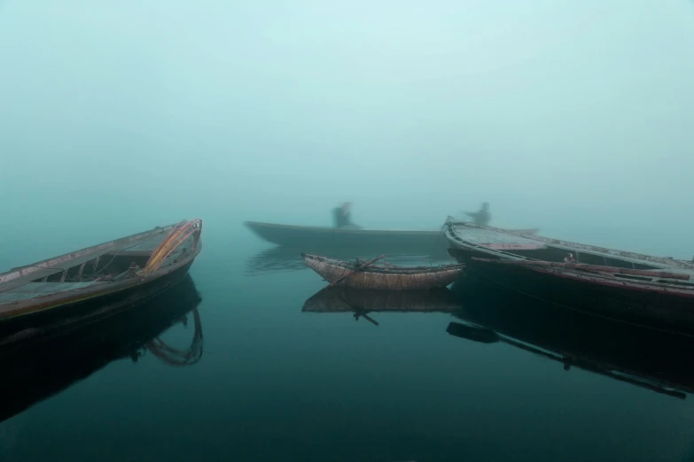 the boats are in the water on a foggy day