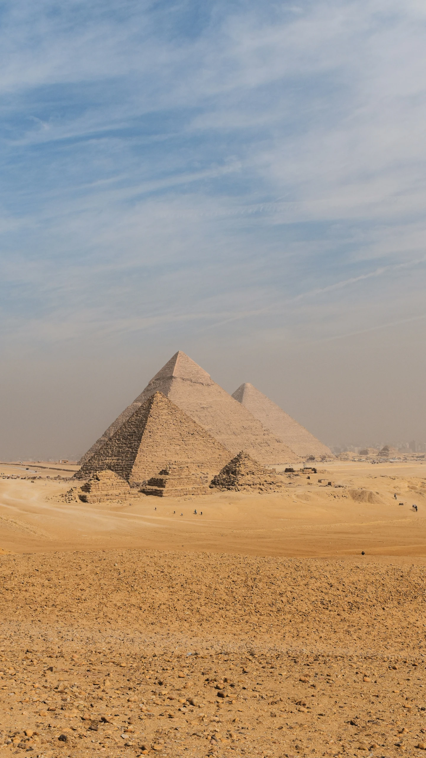 two huge pyramids in the desert with blue skies