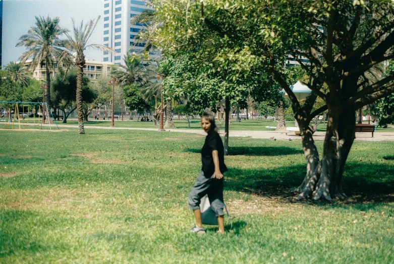 a boy holding a frisbee while walking on grass