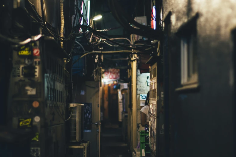 an alley with dark lighting and buildings in the background