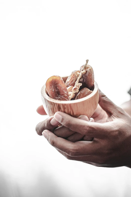 a man holds a bowl of pastries in his hands