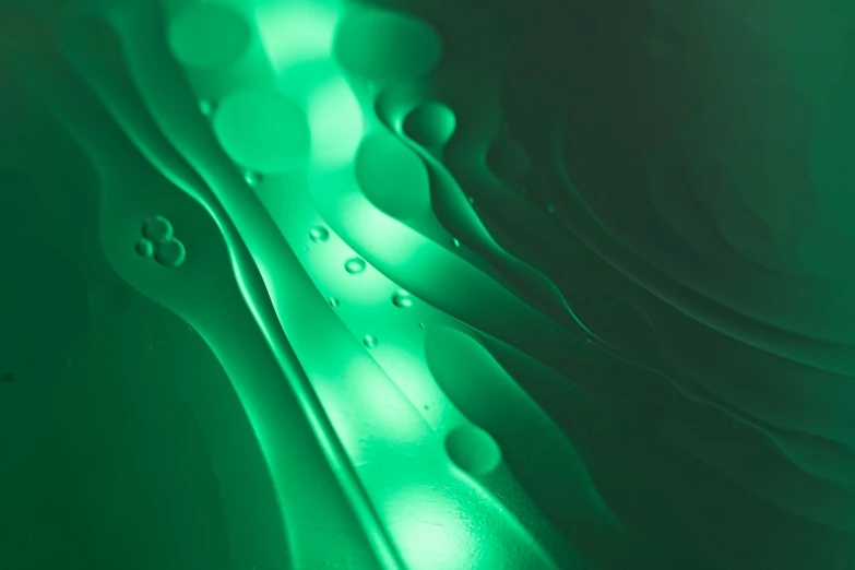 drops of water on a black surface, green and white colors