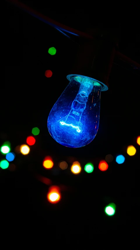 a candle on the table lit by several colored lights