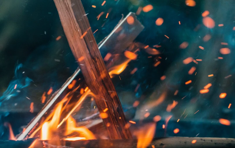 an open fire next to a wooden sign and some kind of thing