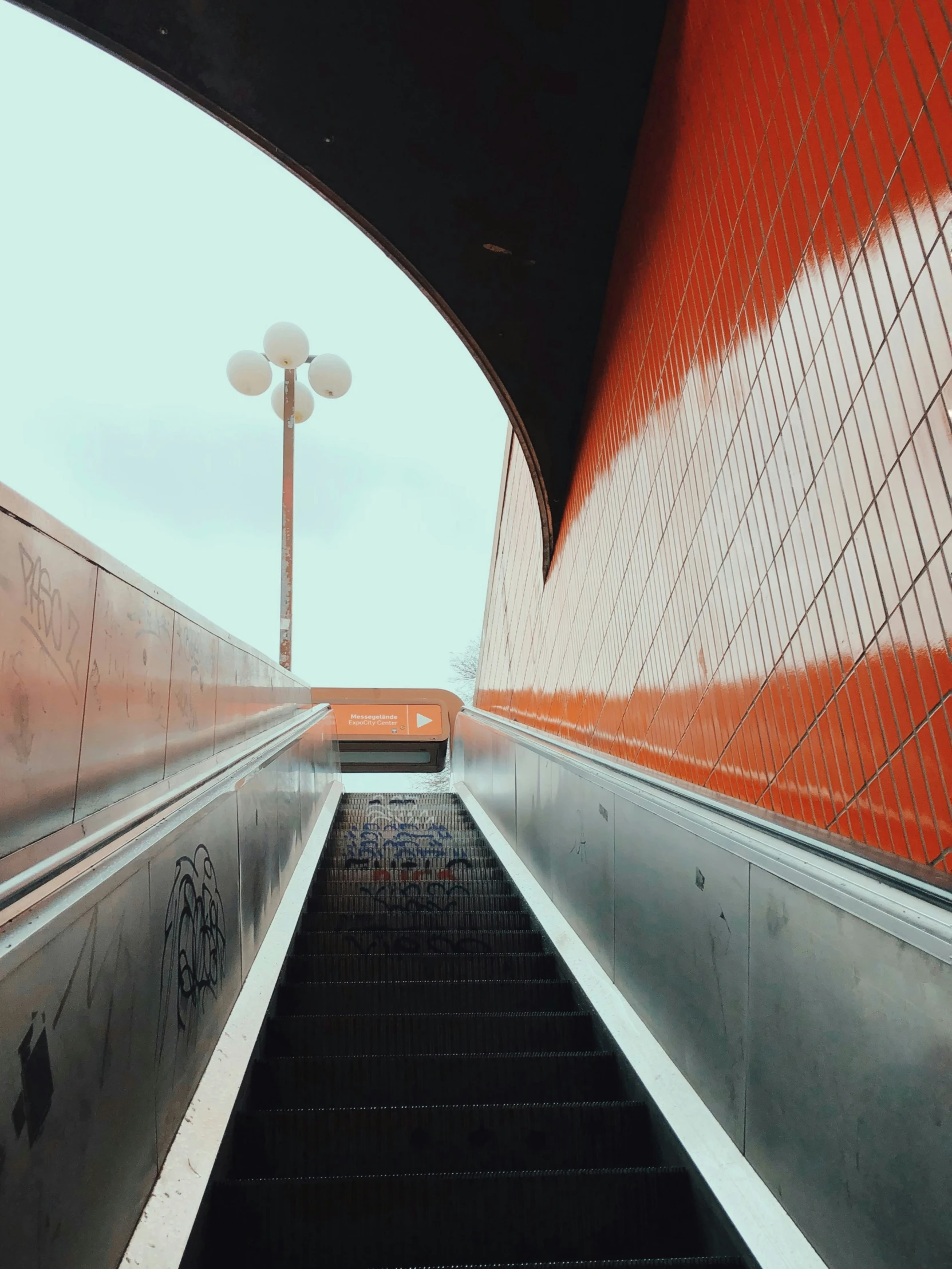 a escalator with red walls leads to another platform