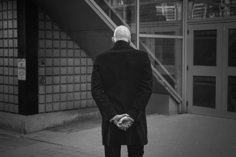 a man in a suit standing on the sidewalk