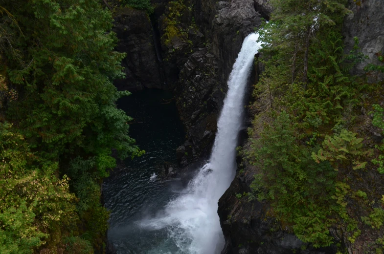 an aerial view of a waterfall as it peeks over the rocks