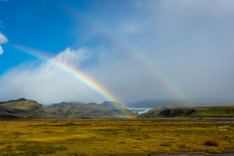 a beautiful rainbow in the distance with mountains behind