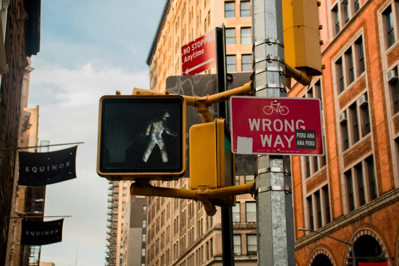 a traffic light that says wrong way in between two buildings