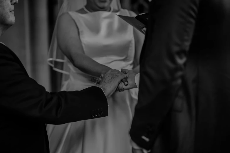 black and white pograph of a bride holding her grooms hand