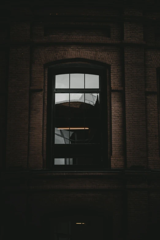 a window in a brick building with a traffic signal lit up