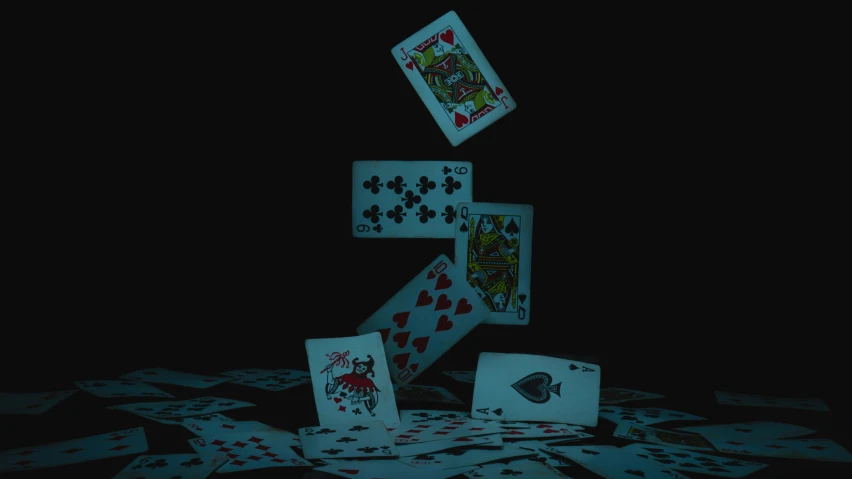 four different cards are falling in the air