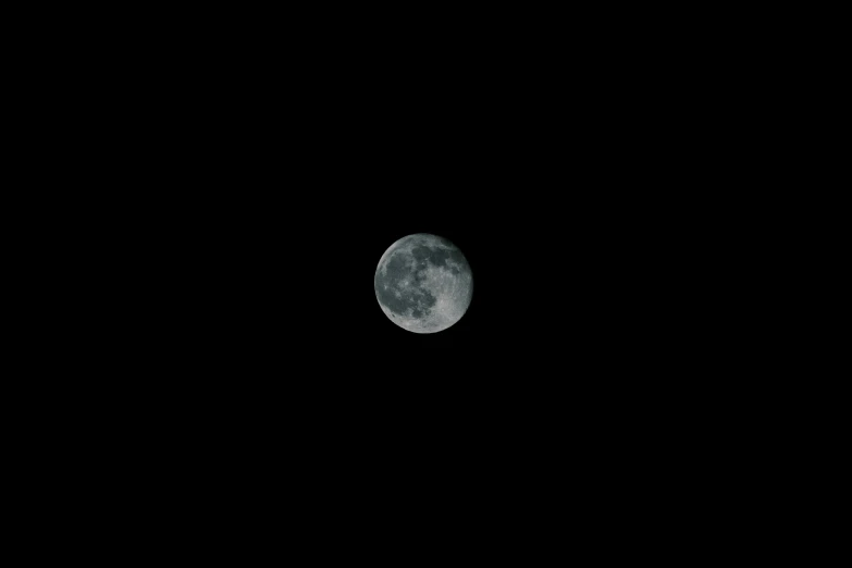 a full moon seen above a dark black night sky