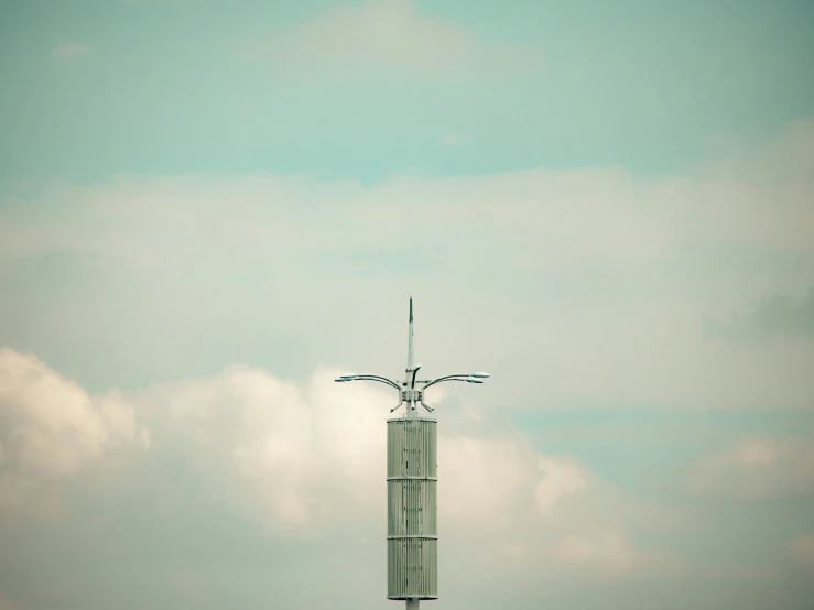 a tall pole that has a weather vane on it