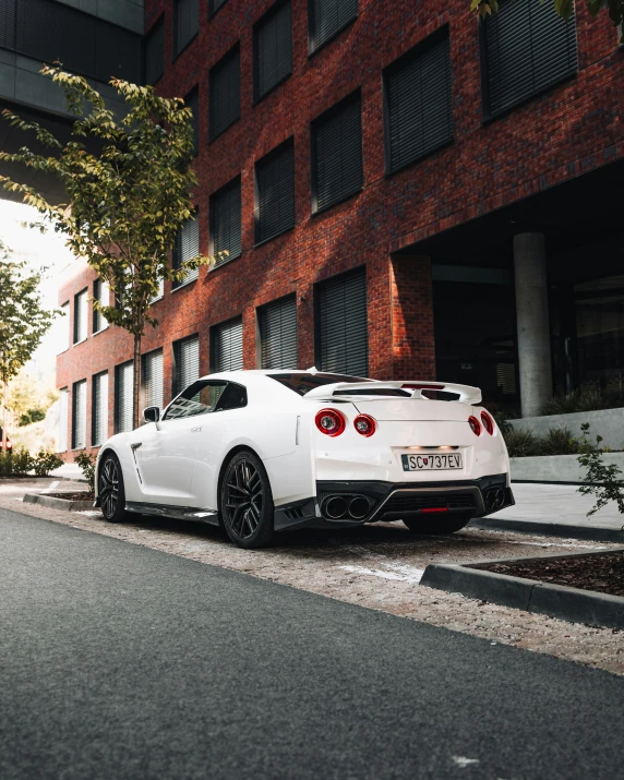 a white sports car is parked next to a building