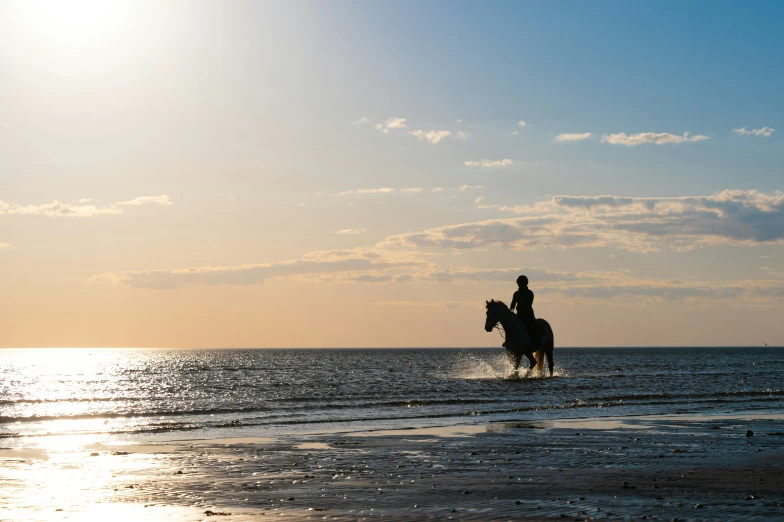 there is a man that is riding a horse across the water