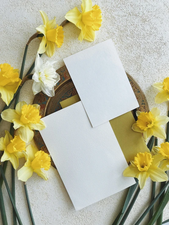 an open piece of paper sitting next to a bunch of flowers