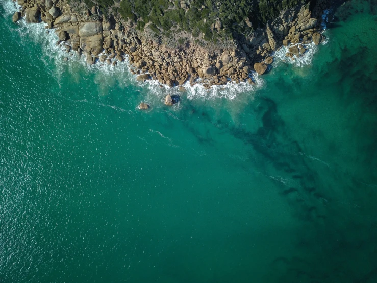 a beach with some water and people swimming in it