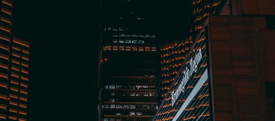 a very tall building is lit up and bright at night