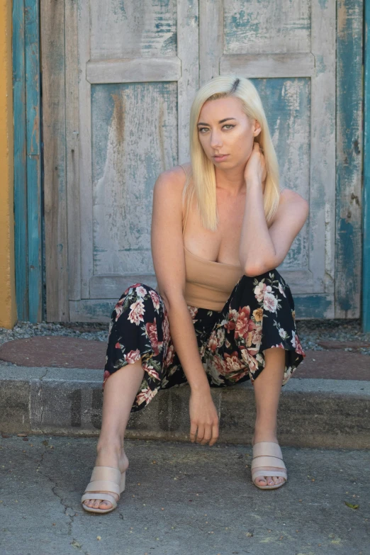 man sitting on step with shirt off in front of old door