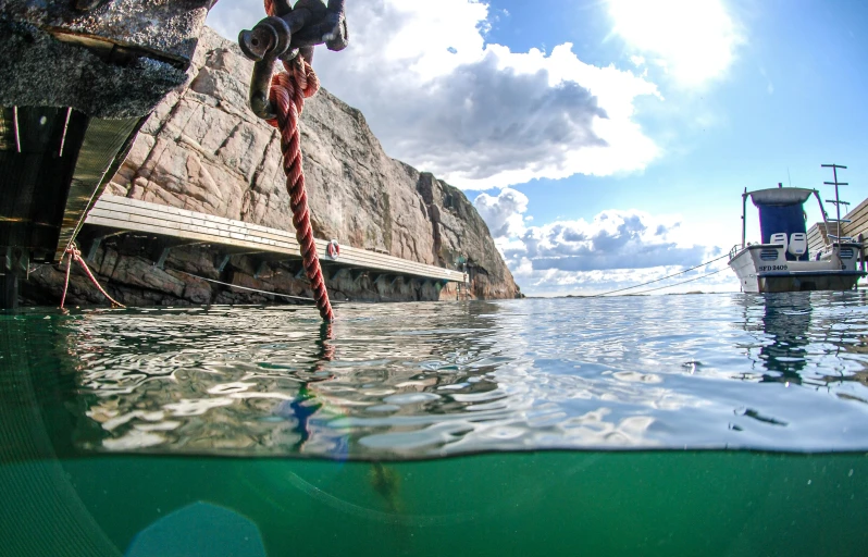 a boat docked in water next to a shore