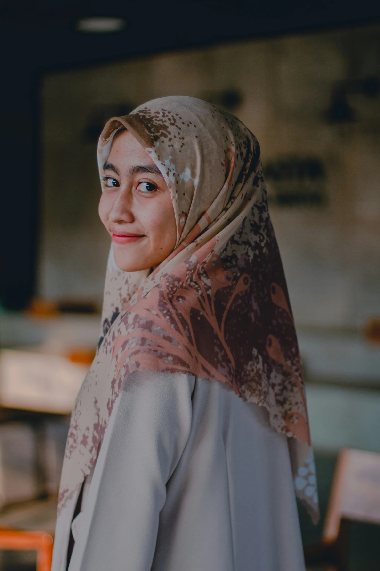 the woman is wearing a head scarf in a cafe